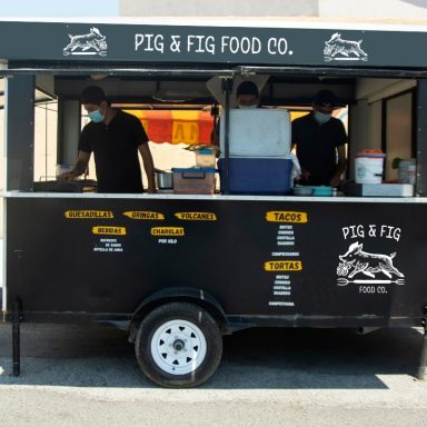 Food truck named "Pig & Fig Food Co." with staff preparing orders.