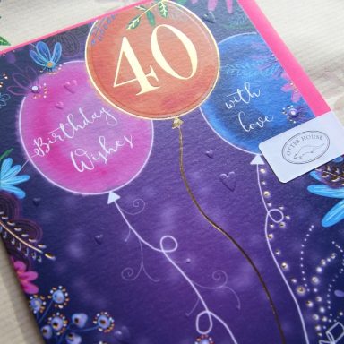 A colourful birthday card featuring balloons and the number 40, adorned with floral designs.