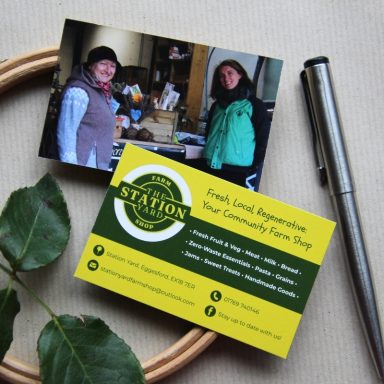 Business cards for a local farm shop featuring two smiling women and a green logo.